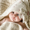 cape de bain bébé en éponge bio capuche imprimée cerises et animée d'un gros noeud